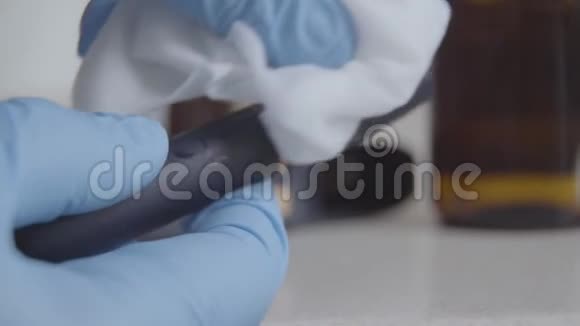 双手戴蓝色防护手套用消毒剂擦拭玛斯卡拉女性在冠状病毒感染期间化妆视频的预览图