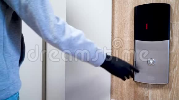 在冠状病毒和传染病流行期间一个戴着黑色防护手套的人按下电梯按钮视频的预览图