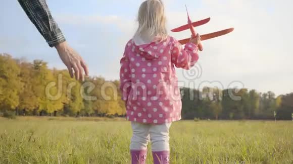 年轻的白种人帮助他可爱的小女儿玩一架粉红色的玩具飞机可爱的金发女郎视频的预览图