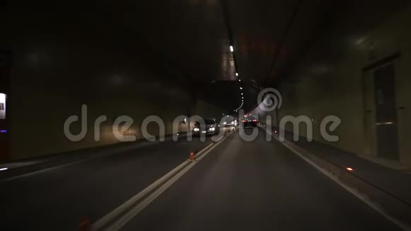 汽车暗车隧道沥青上有白色箭头指示方向多灯紧急出口标志视频的预览图