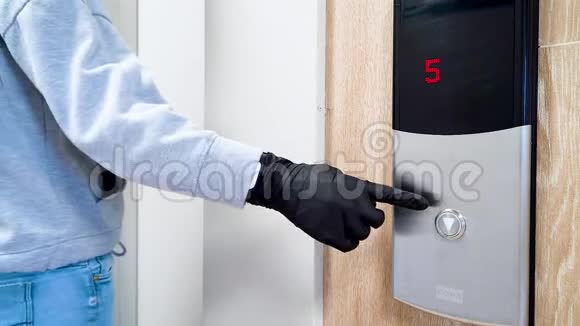 在冠状病毒和传染病流行期间一个戴着黑色防护手套的人按下电梯按钮视频的预览图