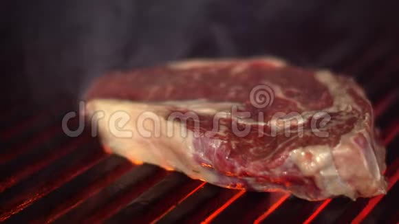 烤架上的一块牛肉肋眼在烧烤上被油炸一块美味的肉在炉火上烤视频的预览图