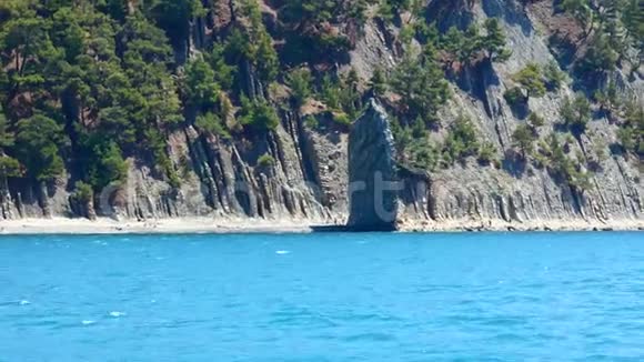 靠近海滩的孤独的平坦岩石从船上可以看到视频的预览图
