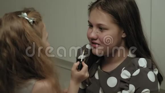 快乐的孩子和穿着裙子的妹妹互相化妆视频的预览图