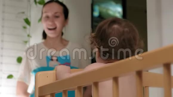 一个女人在婴儿床上玩初学者视频的预览图
