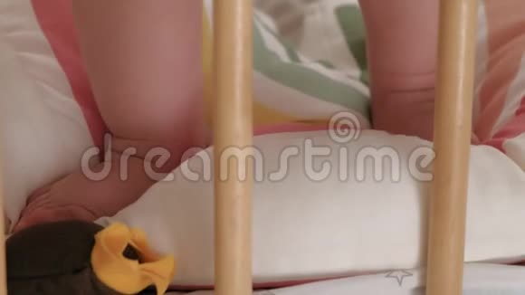 婴儿学步的脚在婴儿床上跳跃视频的预览图