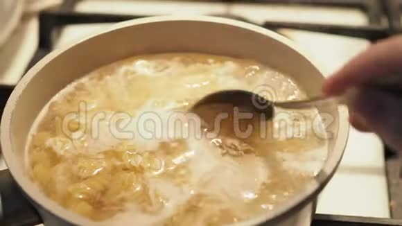 彭尼面条在沸水中煮熟木勺在慢速侧视中搅动意大利面视频的预览图