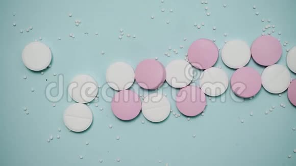 蓝色背景的粉色和白色药片视频的预览图