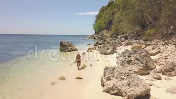 阳光明媚的一天快乐的年轻女子在热带岛屿的沙滩上奔跑鸟瞰欢快的女人在奔跑视频的预览图