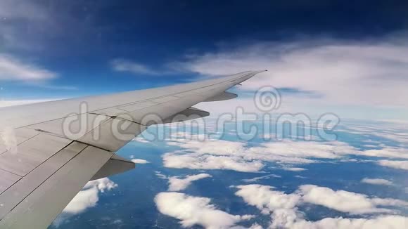 在云层上方加速飞行从飞机机翼上的驱油器看到在地面上飞行的云层时间视频的预览图