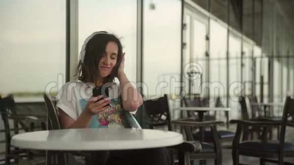 头影中的年轻女子在咖啡馆里放松听音乐视频的预览图