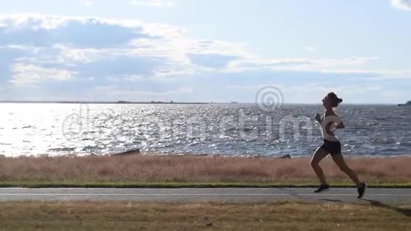 有魅力的女子跑步运动员是在平静的海边慢动作跑步的耐力视频的预览图