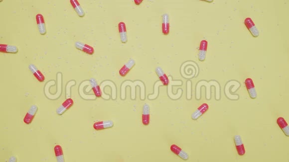 黄色背景的粉色和白色药片视频的预览图