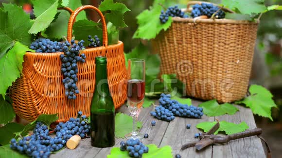 两个篮子葡萄酒瓶和酒杯站在乡村的木头上葡萄酒制作背景视频的预览图