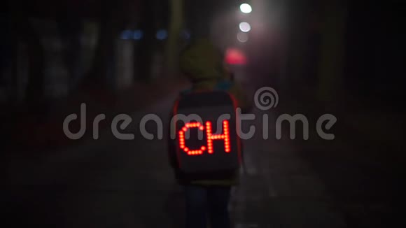 晚上迷路的男孩带着一个发光的背包走在街上视频的预览图