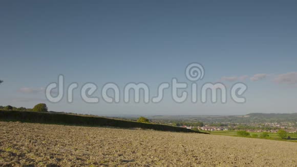 一片覆盖着泥土和草的平原面向城镇视频的预览图