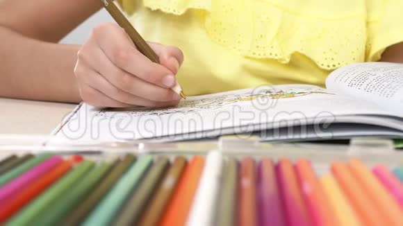 一个女孩画一本彩色书一个小女孩的特写她的手拿着铅笔画画视频的预览图