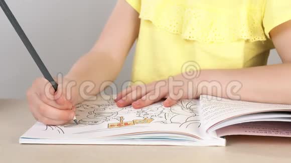 一个女孩画一本彩色书一个小女孩的特写她的手拿着铅笔画画视频的预览图