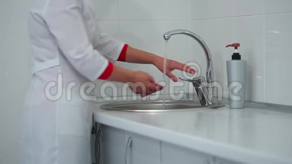 医院一名医务人员擦拭洗手池和水龙头然后擦拭桌子表面视频的预览图