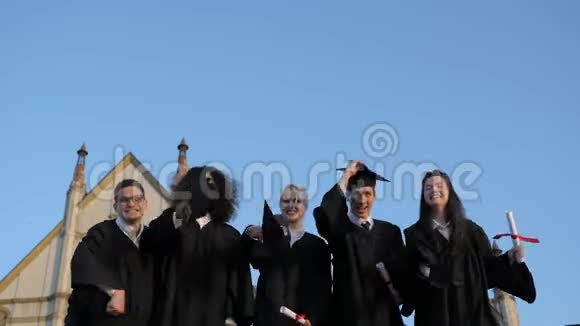一群毕业生高兴地把帽子扔到空中视频的预览图