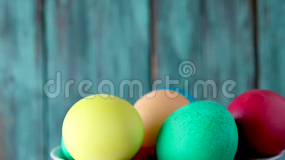 篮子里五颜六色的复活节彩蛋在木制背景上旋转视频的预览图