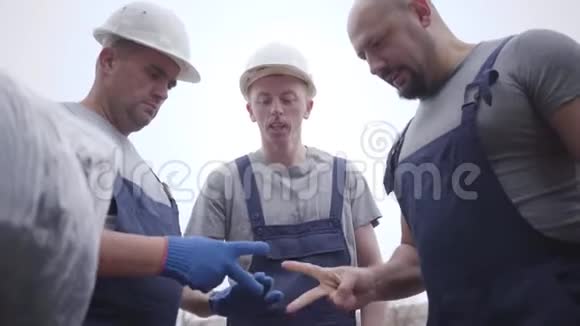 三个白人成年人在玩石头剪刀年轻红头发的家伙输了拿着包裹就走了男子视频的预览图