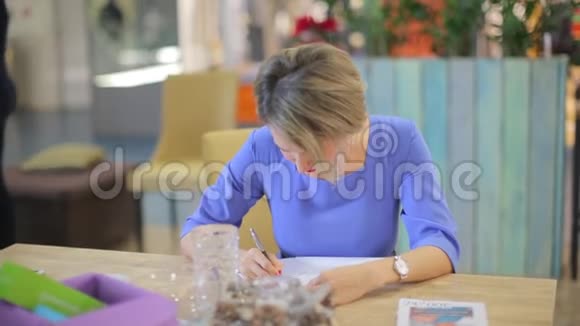 穿蓝色衣服的女人写字视频的预览图