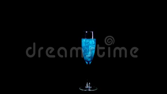 带蓝色液体的玻璃灵丹妙药旋转并溢出液体爱的情感在黑色的背景上是孤立的视频的预览图