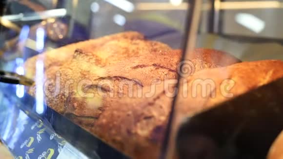 一个男人在超市买热的新面包一个人在面包店里挑选新鲜的白卷视频的预览图