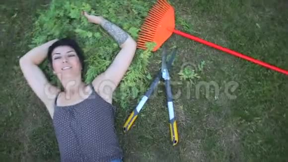 女孩躺在工具旁边的草地上视频的预览图