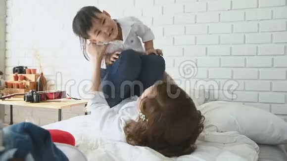 妈妈在家里的卧室里和一个半日本男孩玩飞机幸福的家庭和宝宝概念多种疗法视频的预览图