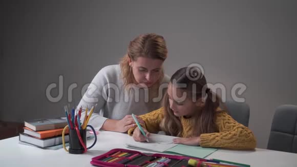 小白种人女孩和妈妈在家做作业年轻女子解释女儿的错误父母视频的预览图