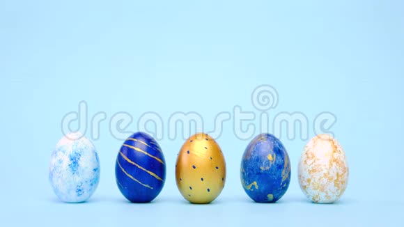复活节彩蛋滚滚互相敲着蓝桌子鸡蛋时髦的颜色经典蓝色白色和金色快乐视频的预览图