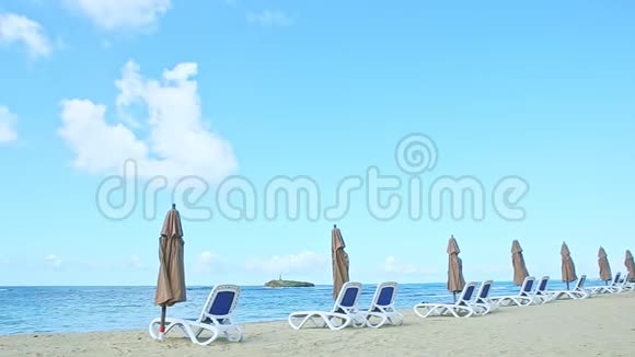 蓝色海洋和金色沙滩全景带沙滩椅和遮阳伞视频的预览图