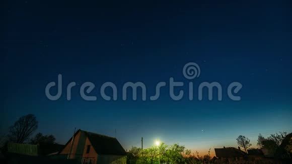 已定夜空背景在村庄房屋之上自然发光恒星的夜景视频的预览图