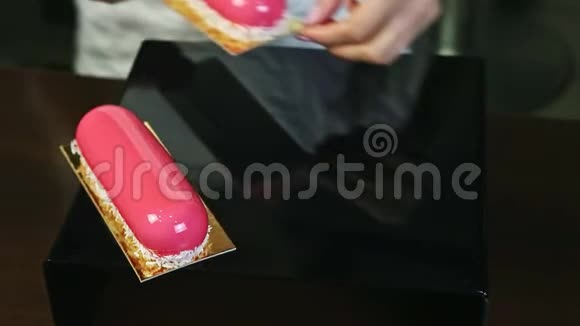 双手甜点是用椰子刨花装饰的粉红色椭圆形釉面视频的预览图