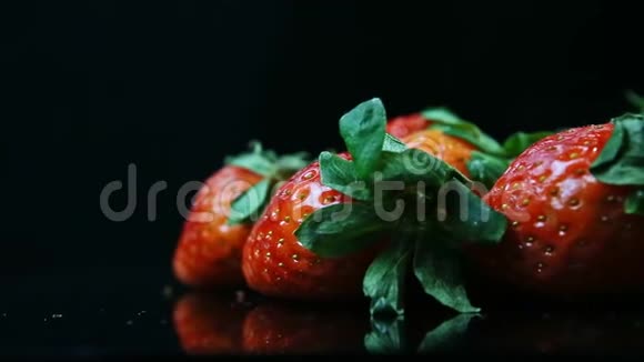 黑色背景下一组成熟的红色草莓的特写全景视频的预览图
