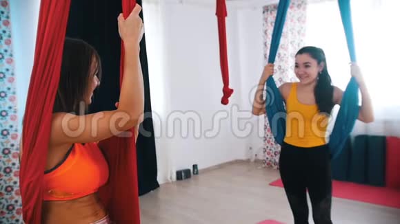 空中瑜伽两个女人坐在吊床上互相交谈视频的预览图