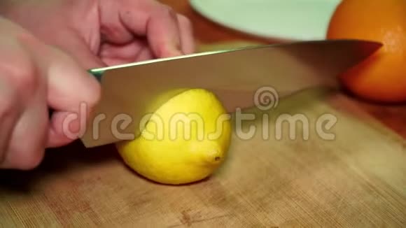 一个女孩在木板上用刀切开一个多汁的成熟维生素黄柠檬视频的预览图