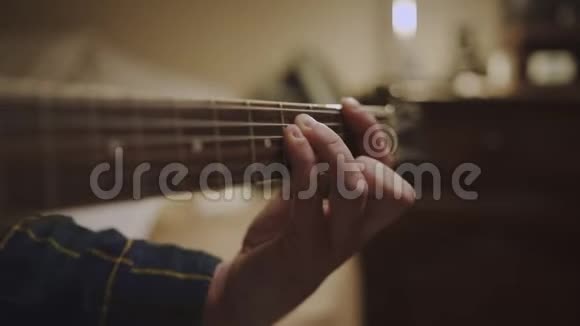 一个吉他手的手指倾斜向上放在吉他的桅杆上弹着和弦在敲击视频的预览图