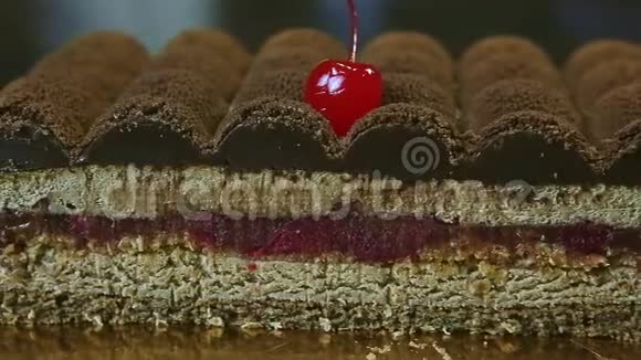 一半现代形状巧克力蛋糕和樱桃夹层的特写全景视频的预览图