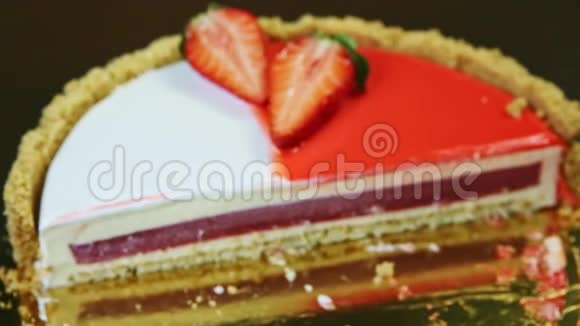 把注意力集中在半个圆形芝士蛋糕上中间有红色果冻和五颜六色的糖霜视频的预览图