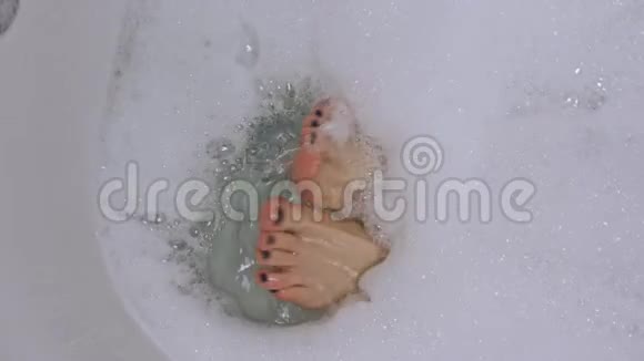 精心打扮的女人她的双腿泡在浴缸里视频的预览图