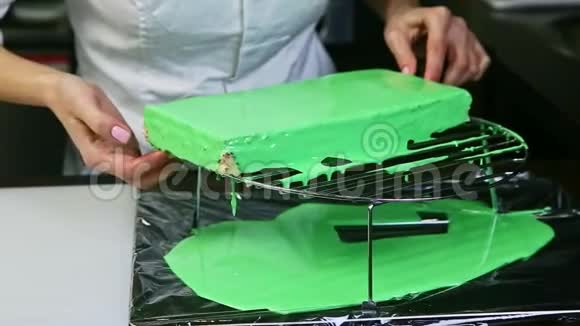 糖果机从金属支架上取出绿色釉层蛋糕并进行白色尝试视频的预览图