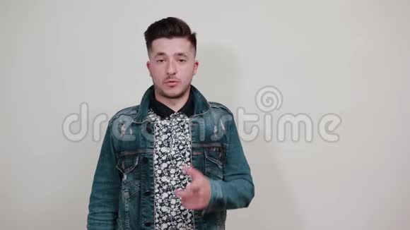 穿着时尚夹克的年轻帅哥指着旁边的广告位视频的预览图