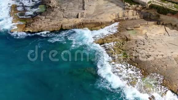 奇妙的土耳其蓝色海水撞击岩石从上往下看视频的预览图
