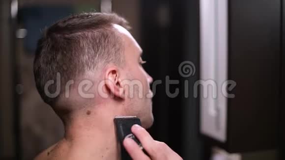 一个人在镜子前用修剪器剪胡子视频的预览图