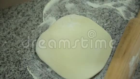一个女人在厨房里洒面粉和面团视频的预览图