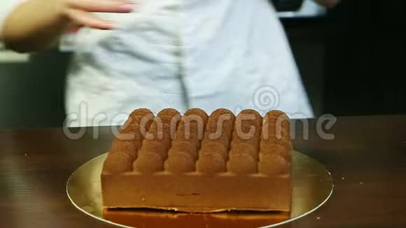 糖果师准备装饰时髦的方形巧克力奶油慕斯蛋糕视频的预览图
