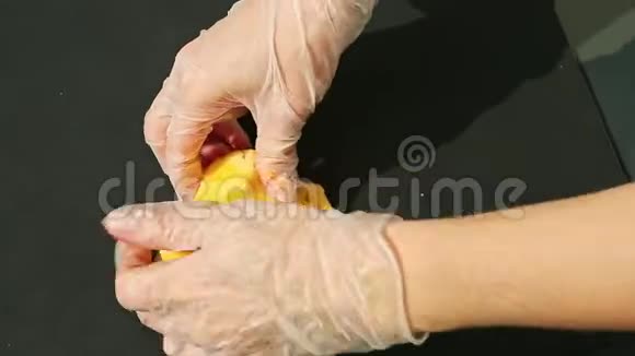 女人手上戴着手套捏着一大块黄色的杏仁糖视频的预览图
